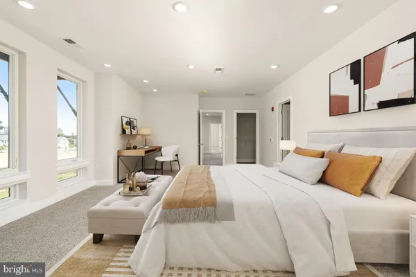 a bedroom with a large bed couch and a window