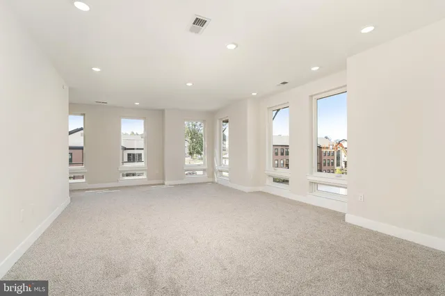 an empty room with windows and entrance to other room