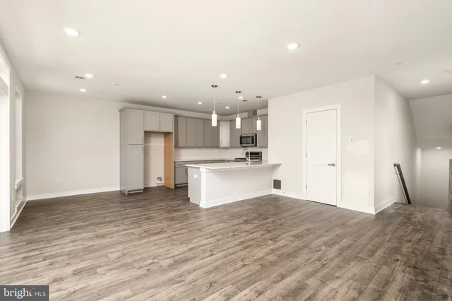 a view of kitchen with refrigerator sink and wooden floor