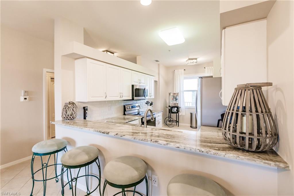 3820 Sawgrass Way, Unit 3043 Naples, FL 34112 - Photo 13 of 44 a kitchen with a sink and a refrigerator