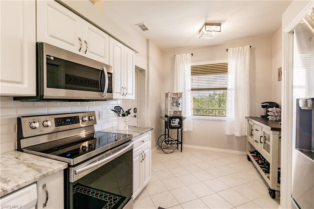 3820 Sawgrass Way, Unit 3043 Naples, FL 34112 - Photo 19 of 44 a kitchen with a stove and a microwave