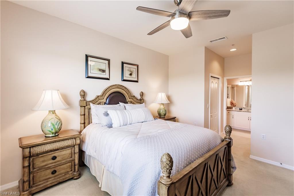 3820 Sawgrass Way, Unit 3043 Naples, FL 34112 - Photo 23 of 44 a bedroom with a bed and a chandelier