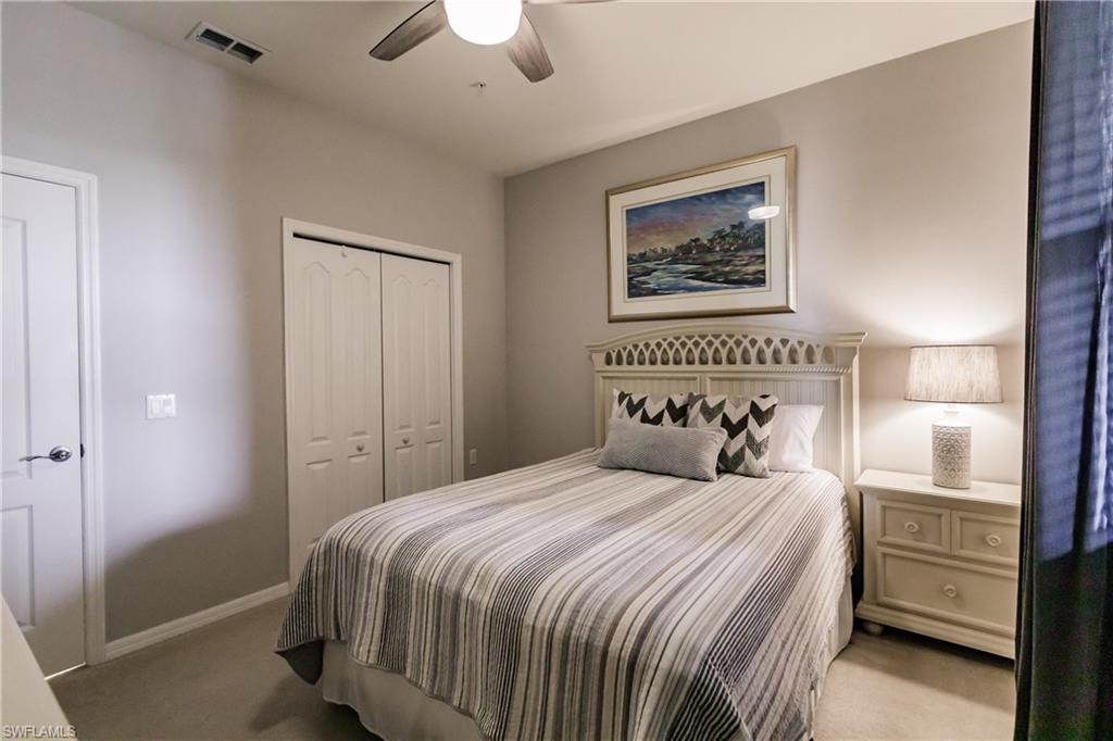 3820 Sawgrass Way, Unit 3043 Naples, FL 34112 - Photo 27 of 44 a bedroom with a large bed and a chandelier