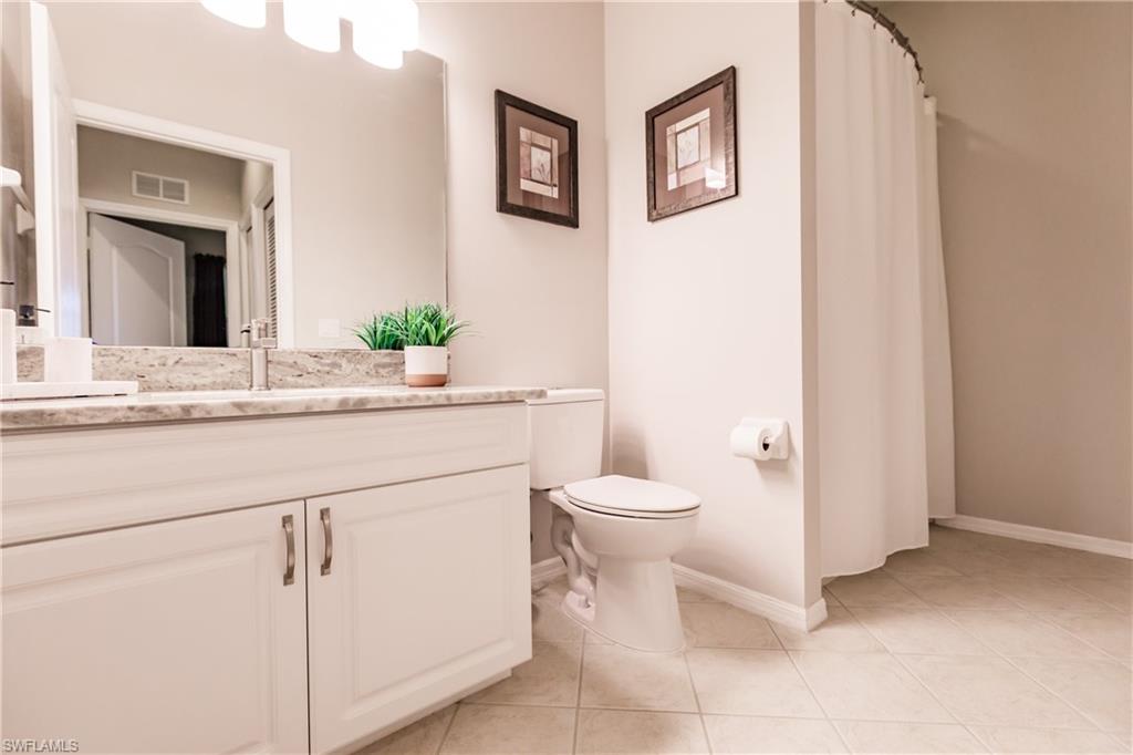 3820 Sawgrass Way, Unit 3043 Naples, FL 34112 - Photo 28 of 44 a bathroom with a toilet sink and mirror