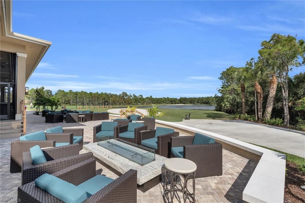 3820 Sawgrass Way, Unit 3043 Naples, FL 34112 - Photo 37 of 44 a view of a patio with couches and table and chairs and potted plants