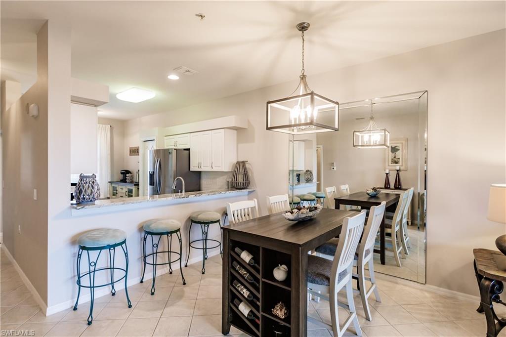3820 Sawgrass Way, Unit 3043 Naples, FL 34112 - Photo 8 of 44 a view of a dining room and livingroom furniture wooden floor and a chandelier