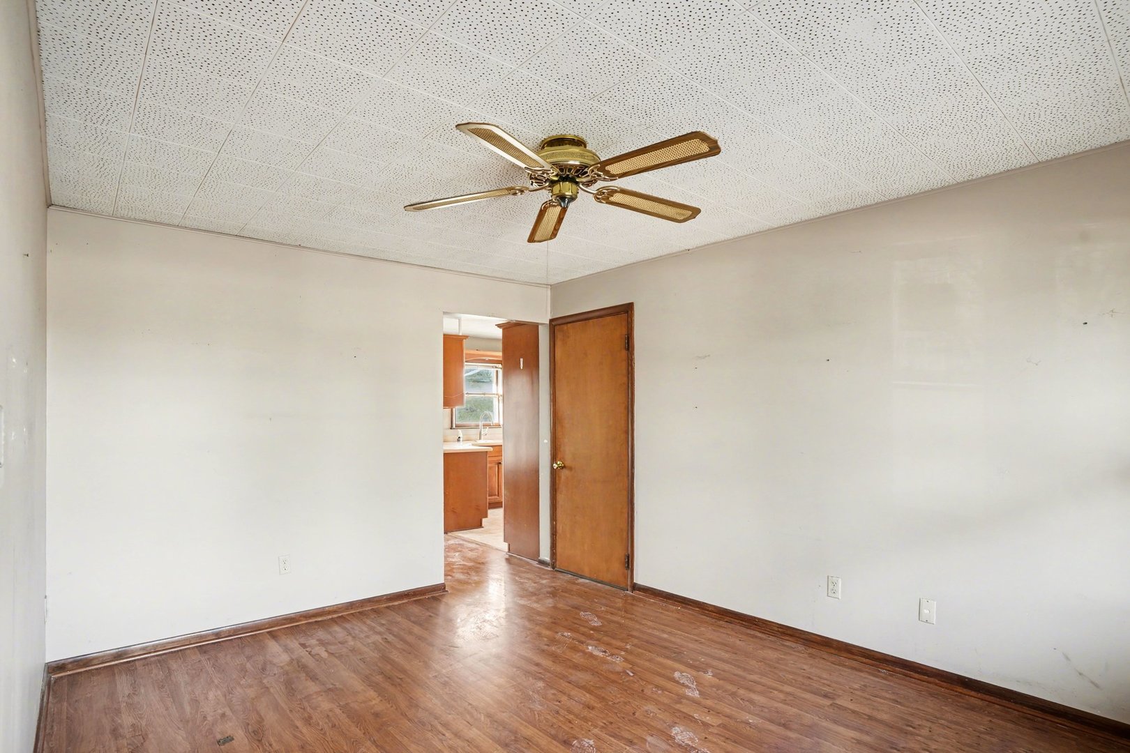 1124 West Hawkins Street Kankakee, IL 60901 - Photo 13 of 22 an empty room with wooden floor and a ceiling fan