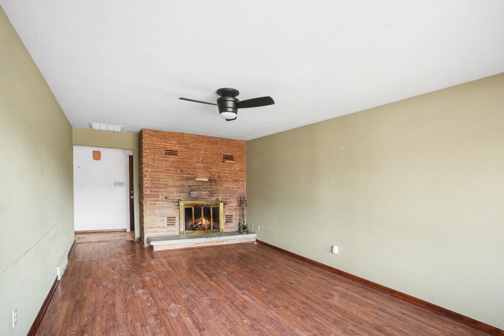 1124 West Hawkins Street Kankakee, IL 60901 - Photo 2 of 22 an empty room with a fireplace and wooden floor