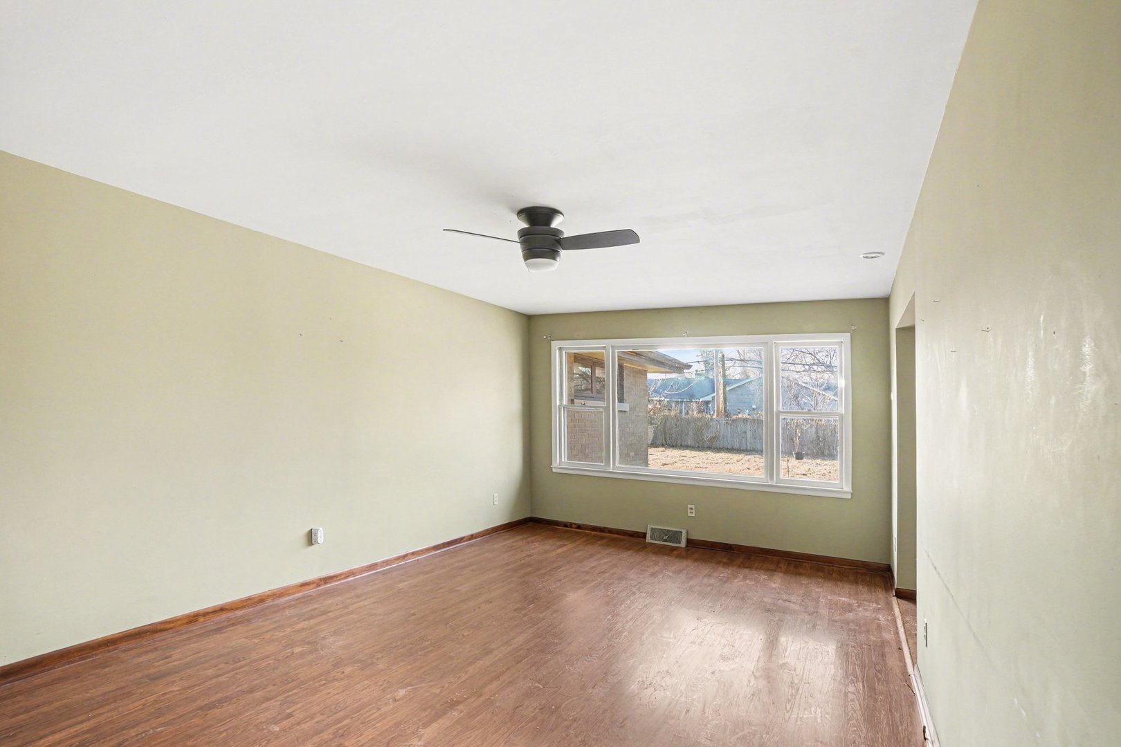 1124 West Hawkins Street Kankakee, IL 60901 - Photo 3 of 22 an empty room with wooden floor and windows
