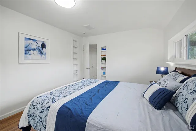 a bedroom with a bed and a painting on the wall