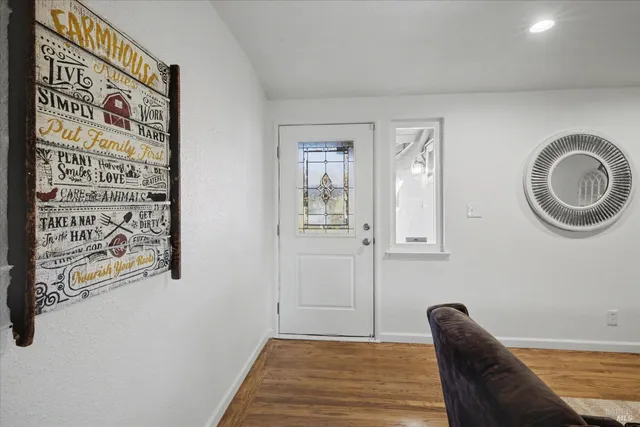 a view of a hallway with wooden floor and a bookshelf