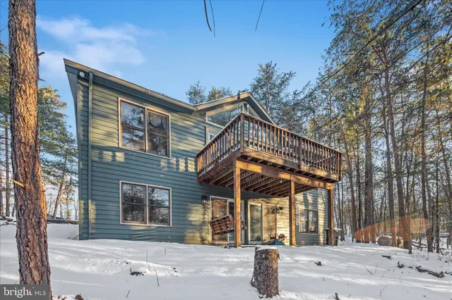 a view of a wooden house with large trees