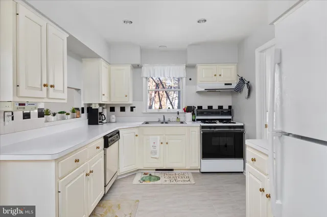 a kitchen with granite countertop white cabinets and white appliances