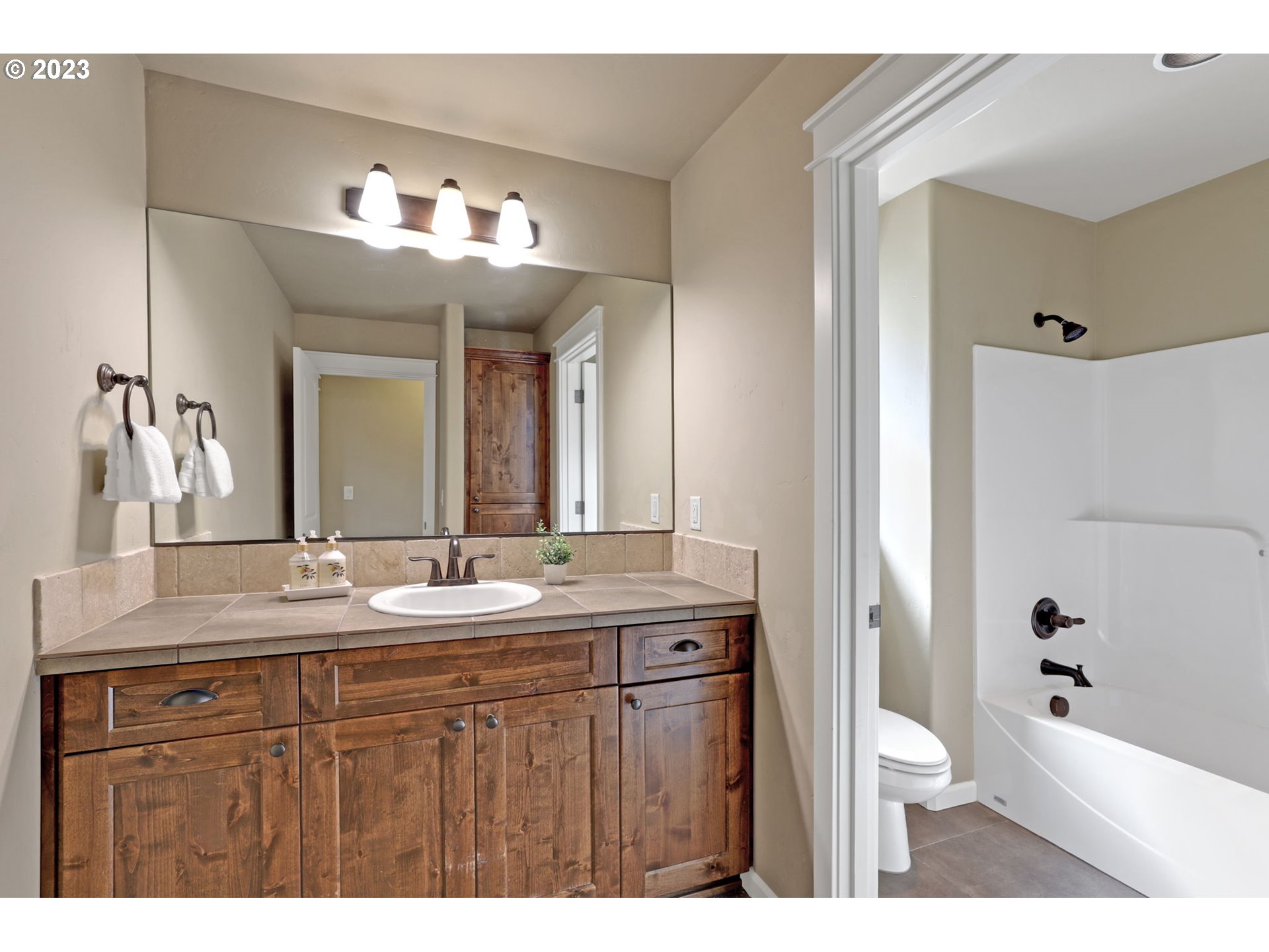 9806 Northwest Wayne Lane Portland, OR 97229 - Photo 20 of 21 a bathroom with a sink a toilet a large mirror and shower