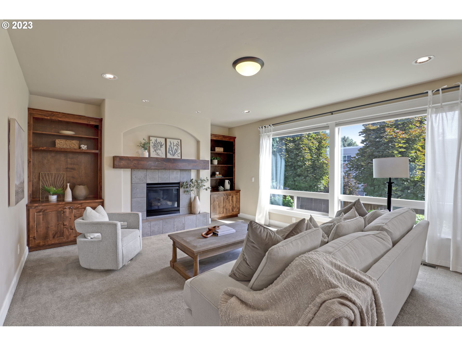 9806 Northwest Wayne Lane Portland, OR 97229 - Photo 3 of 21 a living room with furniture a large window and a fireplace