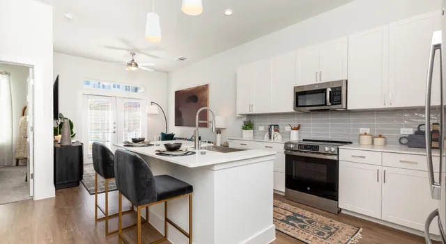 a kitchen with stainless steel appliances granite countertop a stove a sink dishwasher a stove a refrigerator with a dining table and chairs