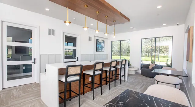 a living room with furniture a flat screen tv and kitchen view