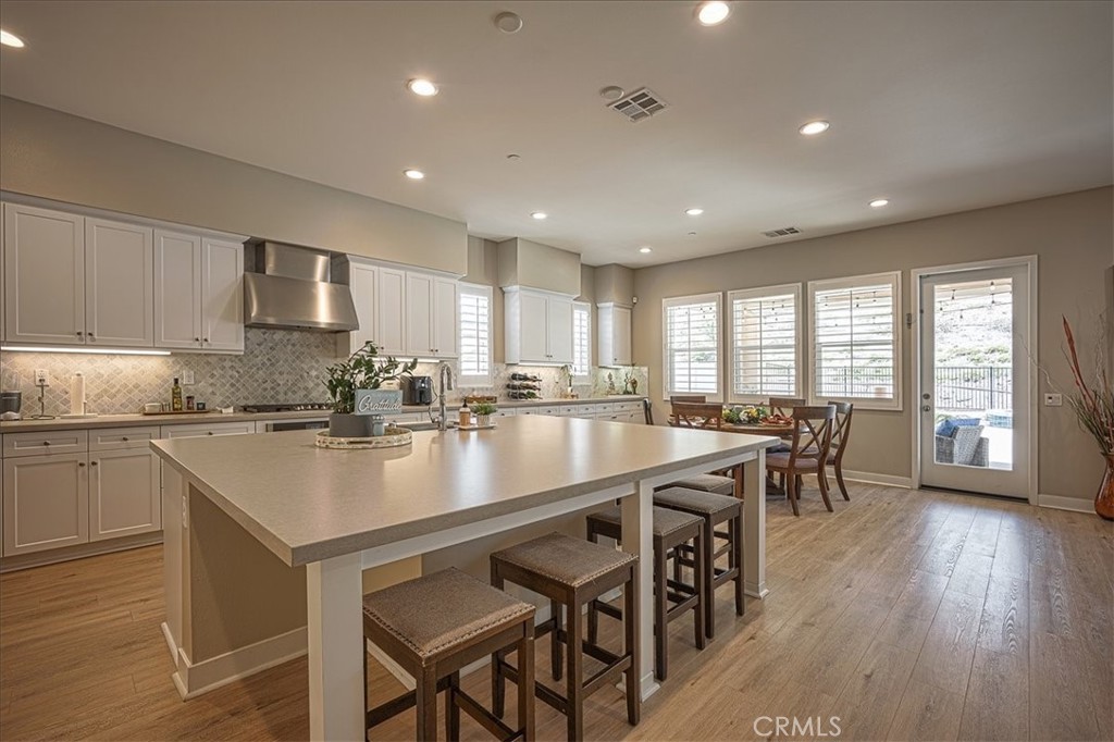 13471 Planet Court Riverside, CA 92503 - Photo 26 of 51 a large kitchen with kitchen island a dining table and chairs