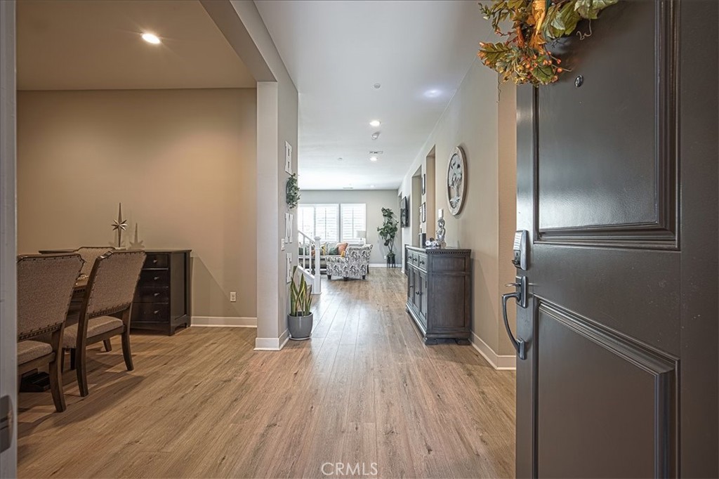 13471 Planet Court Riverside, CA 92503 - Photo 5 of 51 a view of a hallway with wooden floor a glass table and chairs
