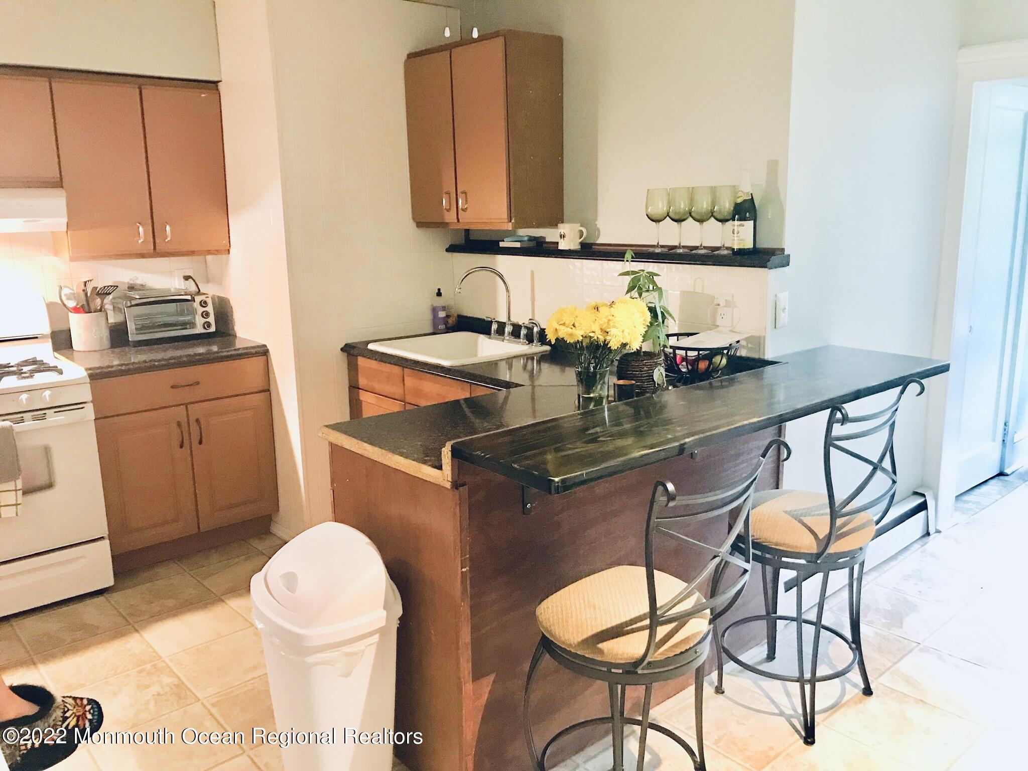 1737 Belmar Boulevard, Unit A Belmar, NJ 07719 - Photo 8 of 15 a bathroom with a granite countertop sink a toilet and a mirror