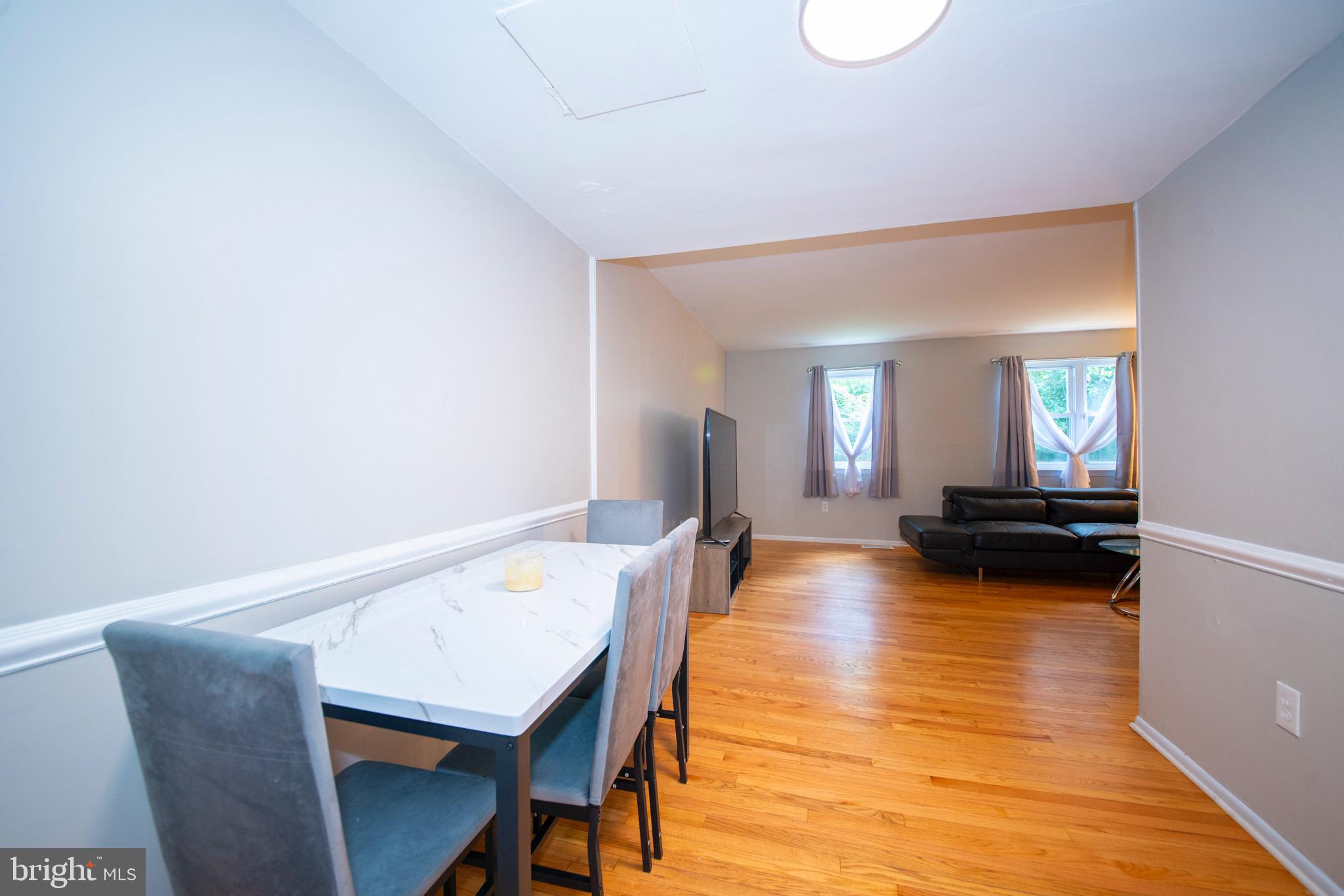 9355 Pan Ridge Road, Unit 9355 Parkville, MD 21234 - Photo 13 of 32 a view of a dining room with furniture and wooden floor