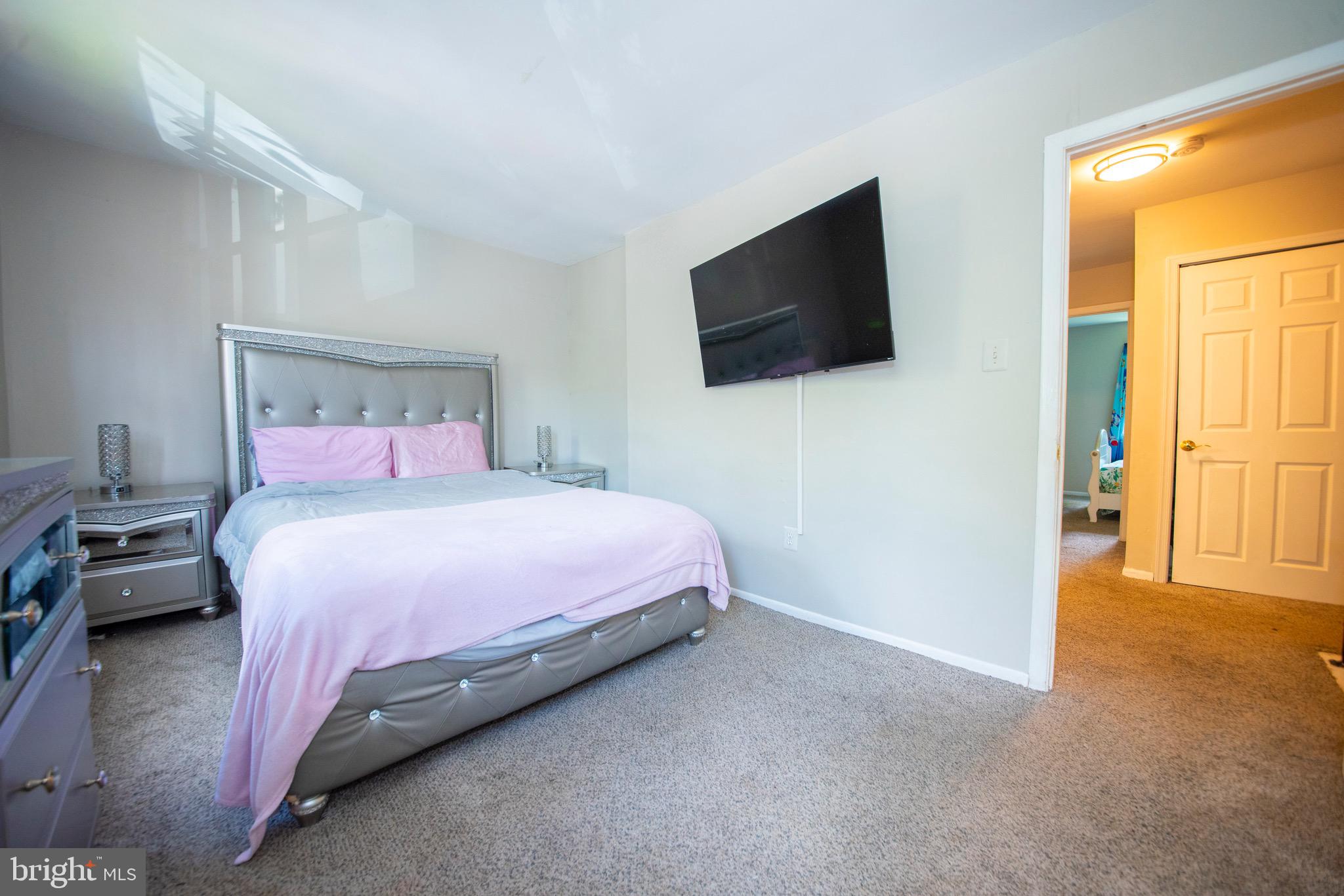 9355 Pan Ridge Road, Unit 9355 Parkville, MD 21234 - Photo 16 of 32 a bedroom with a bed and a flat screen tv