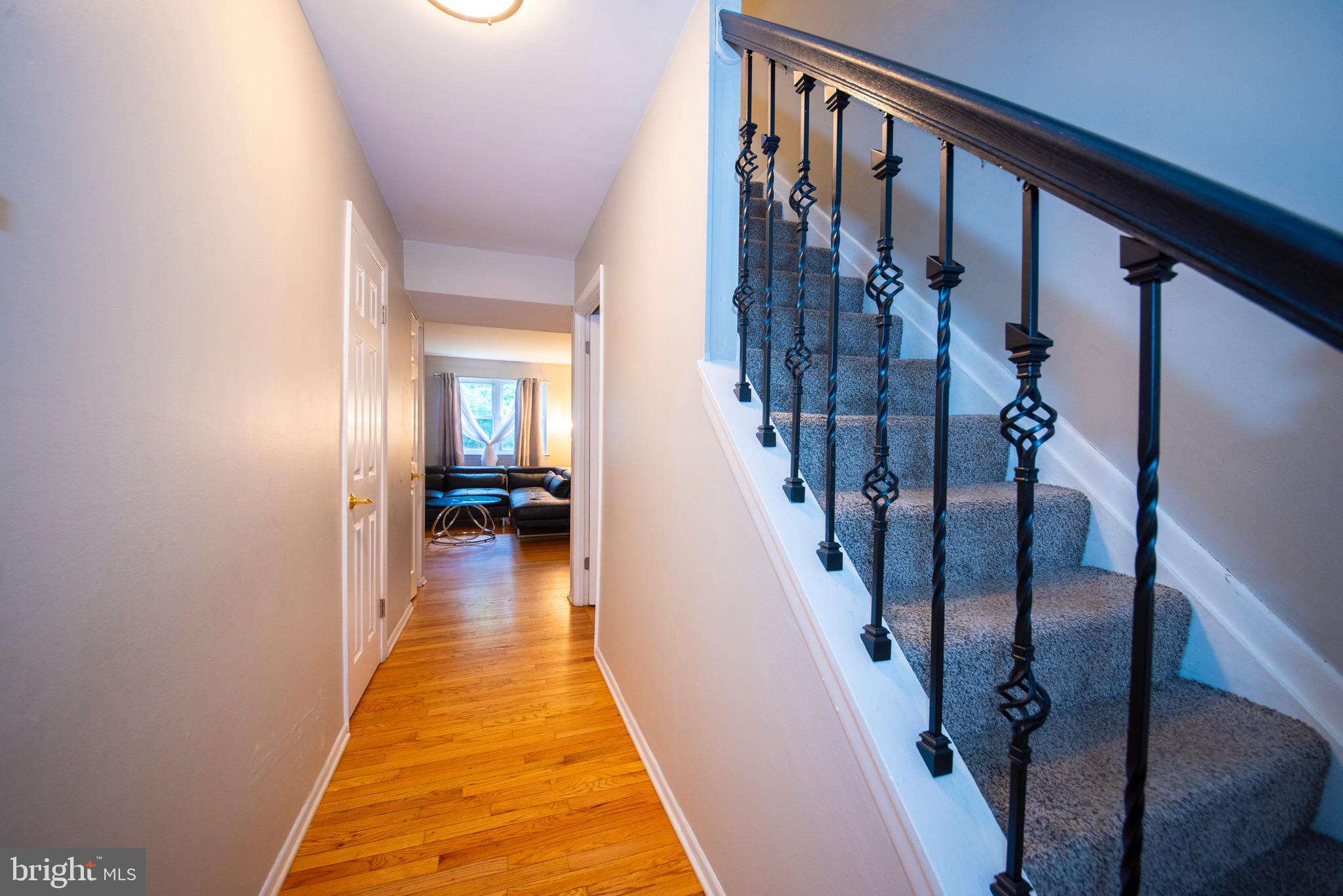 9355 Pan Ridge Road, Unit 9355 Parkville, MD 21234 - Photo 5 of 32 a view of a hallway with wooden floor and staircase