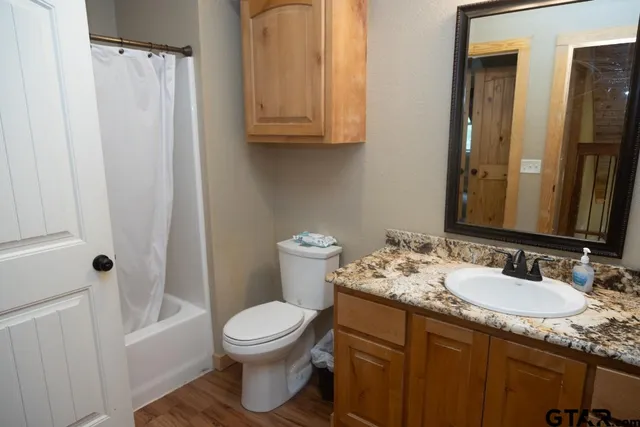 a bathroom with a granite countertop sink toilet and shower