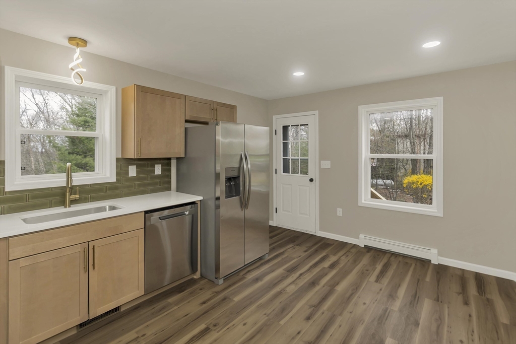 374 Rondeau Street Palmer, MA 01069 - Photo 5 of 27 a kitchen with stainless steel appliances granite countertop a refrigerator a sink and white cabinets with wooden floor
