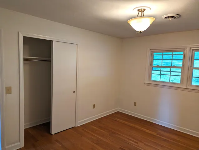 an empty room with windows and a fireplace