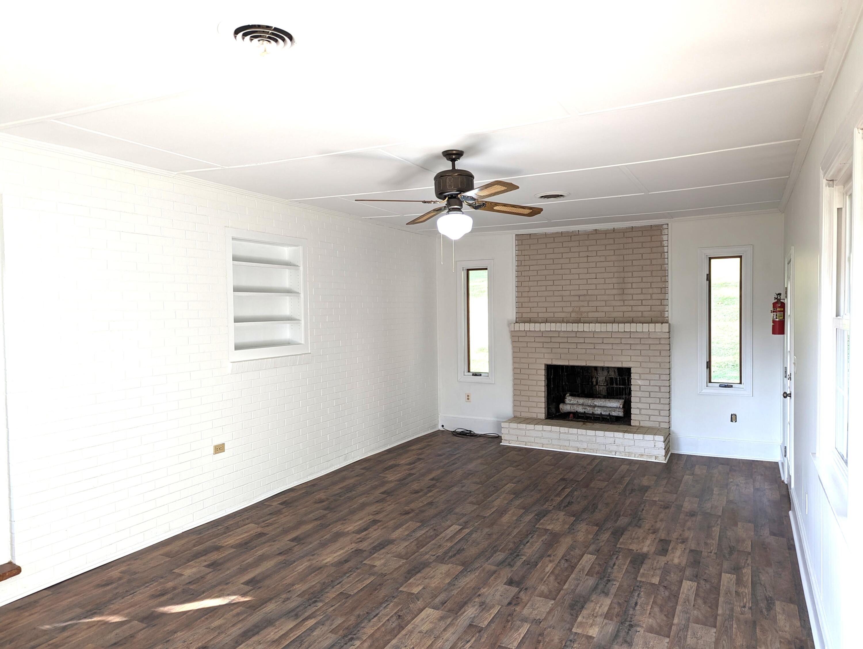 1769 Factory Hill Road Callaway, VA 24067 - Photo 27 of 53 a view of a livingroom with a fireplace a ceiling fan and wooden floor