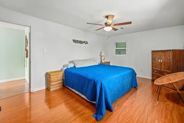 a bedroom with a bed and wooden floor