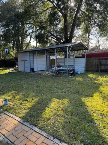 a view of a house with a yard garage and furniture