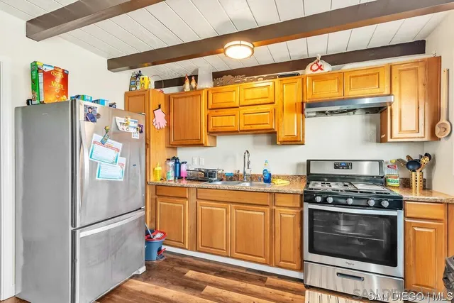 a kitchen with stainless steel appliances granite countertop a refrigerator and a stove top oven