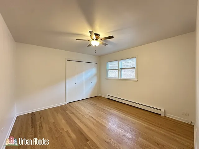 an empty room with a window and a ceiling fan