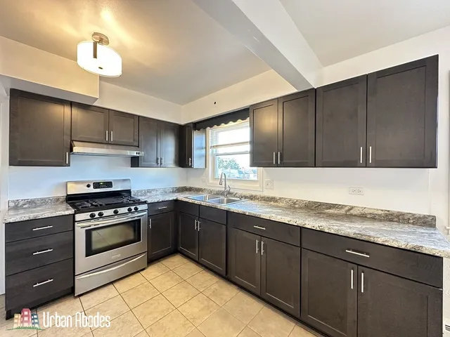 a kitchen with stainless steel appliances granite countertop wooden cabinets a stove a sink and dishwasher