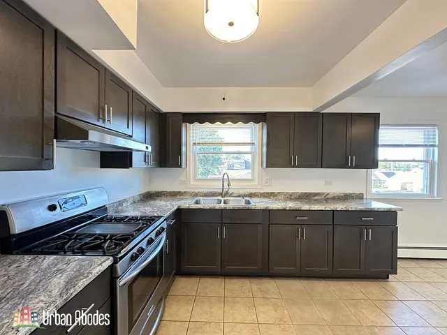 a kitchen with stainless steel appliances granite countertop a sink a stove a refrigerator and cabinets