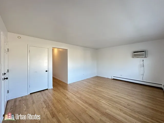 a view of an empty room with wooden floor