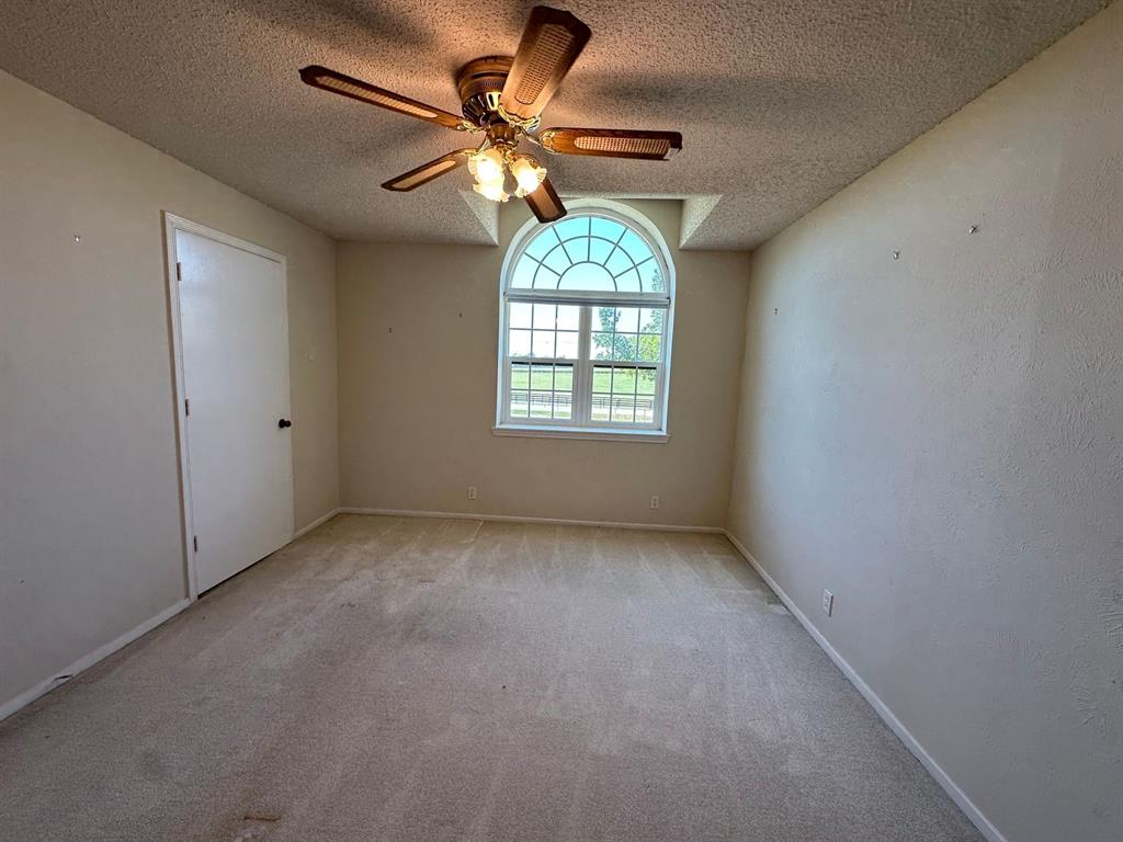 11552 Massey Road Pilot Point, TX 76258 - Photo 19 of 38 an empty room with windows and fan