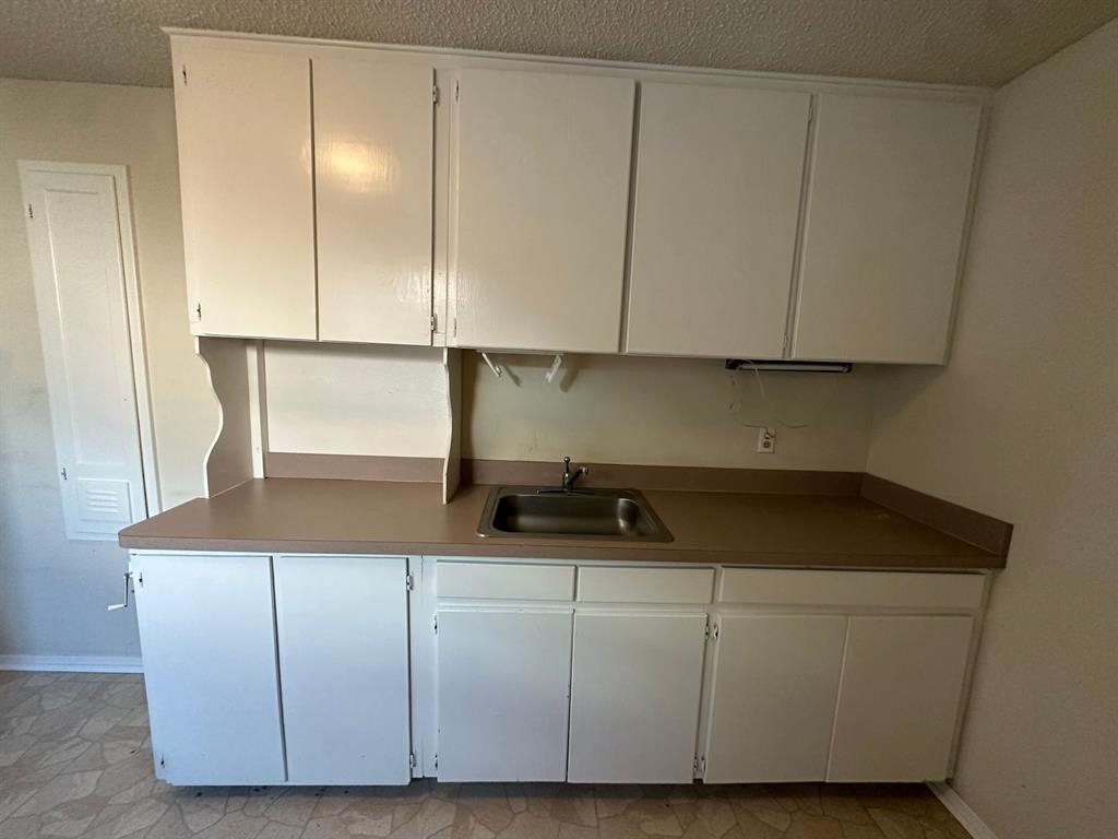 11552 Massey Road Pilot Point, TX 76258 - Photo 38 of 38 a kitchen with cabinets and white appliances