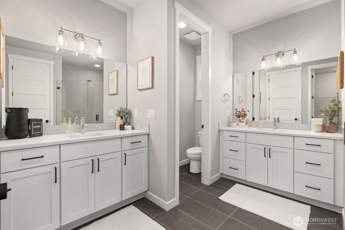 7879 South 132nd Street Seattle, WA 98178 - Photo 22 of 37 a spacious bathroom with double sink a mirror a toilet and a shower
