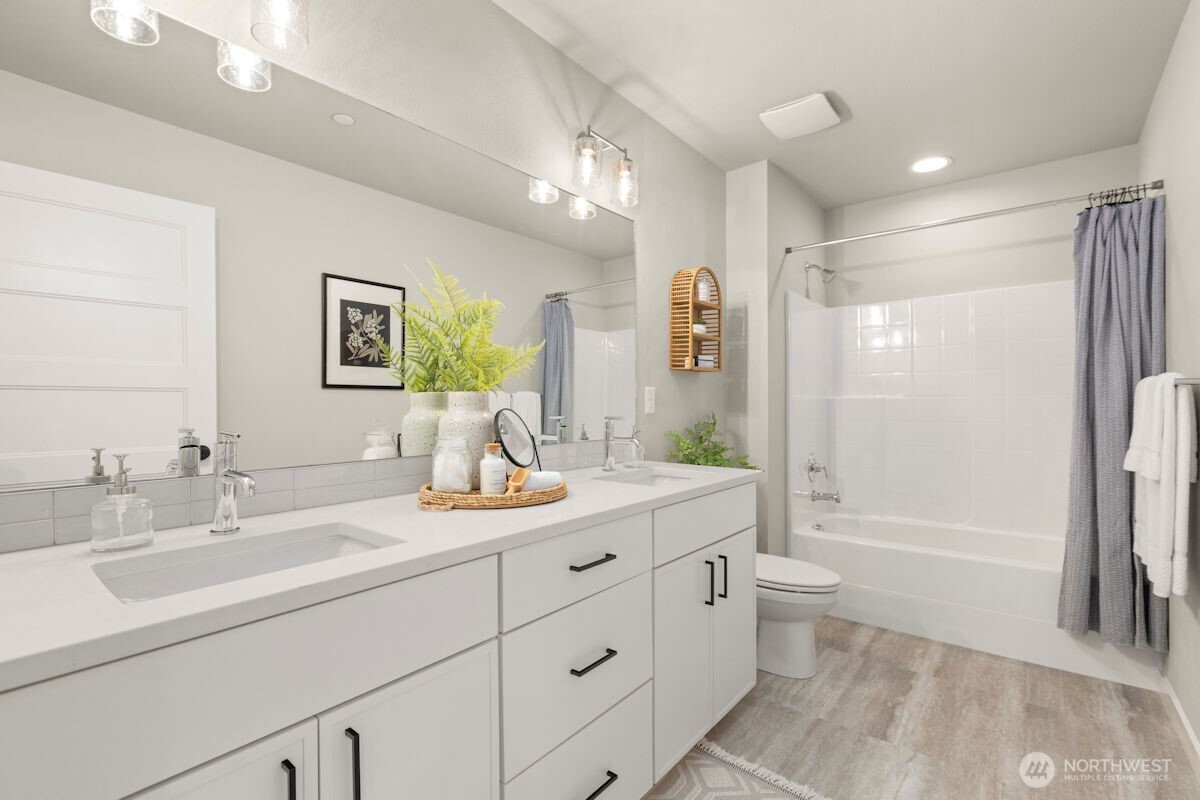 7879 South 132nd Street Seattle, WA 98178 - Photo 27 of 37 a bathroom with a double vanity sink toilet mirror and bathtub