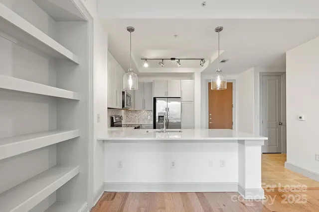 a view of a kitchen with a sink and refrigerator