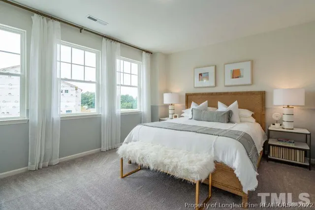 a bed sitting in a bedroom next to a window