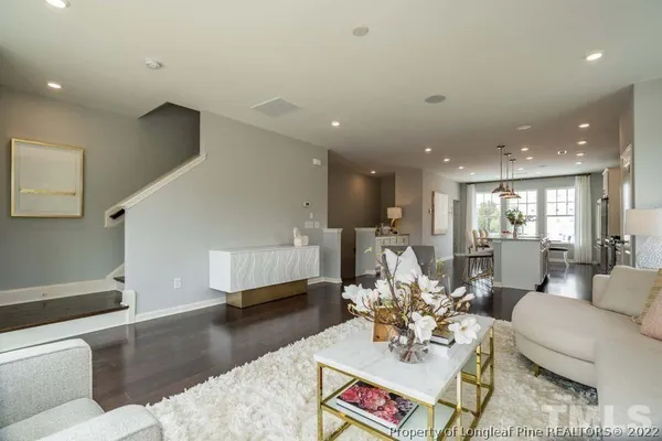 a living room with furniture and a view of kitchen