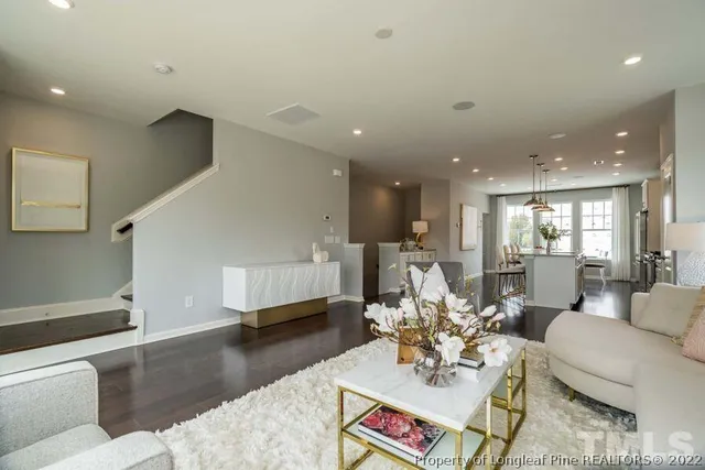 a living room with furniture and a view of kitchen
