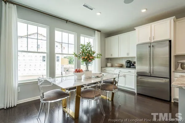 a kitchen with refrigerator cabinets dining table and chairs