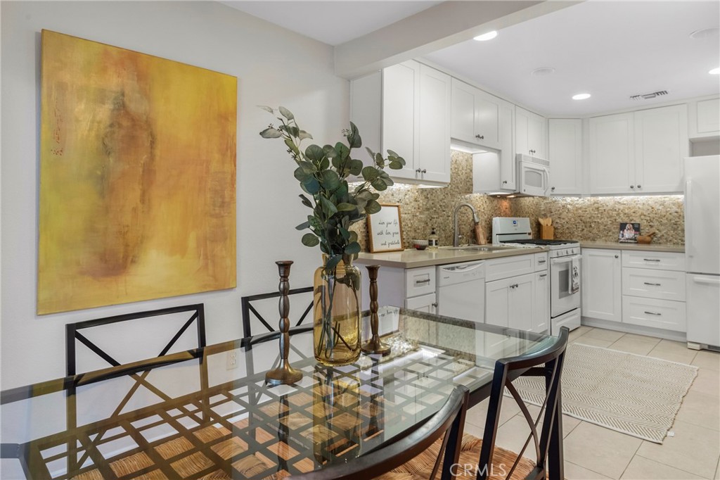 2172 Biscayne Costa Mesa, CA 92627 - Photo 11 of 18 a kitchen with stainless steel appliances kitchen island granite countertop a table and chairs in it