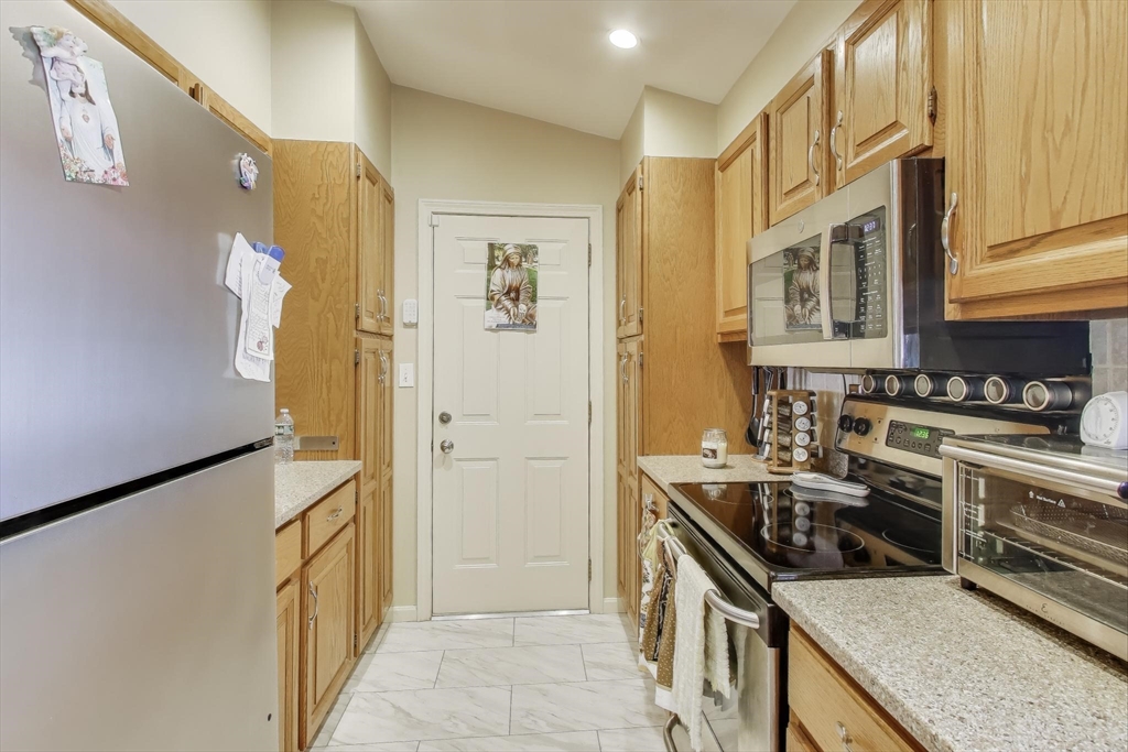 425 Main Street, Unit 11B Hudson, MA 01749 - Photo 11 of 26 a kitchen with stainless steel appliances granite countertop a stove and a refrigerator