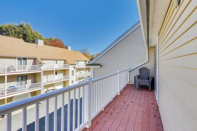 a view of a balcony with wooden floor and fence
